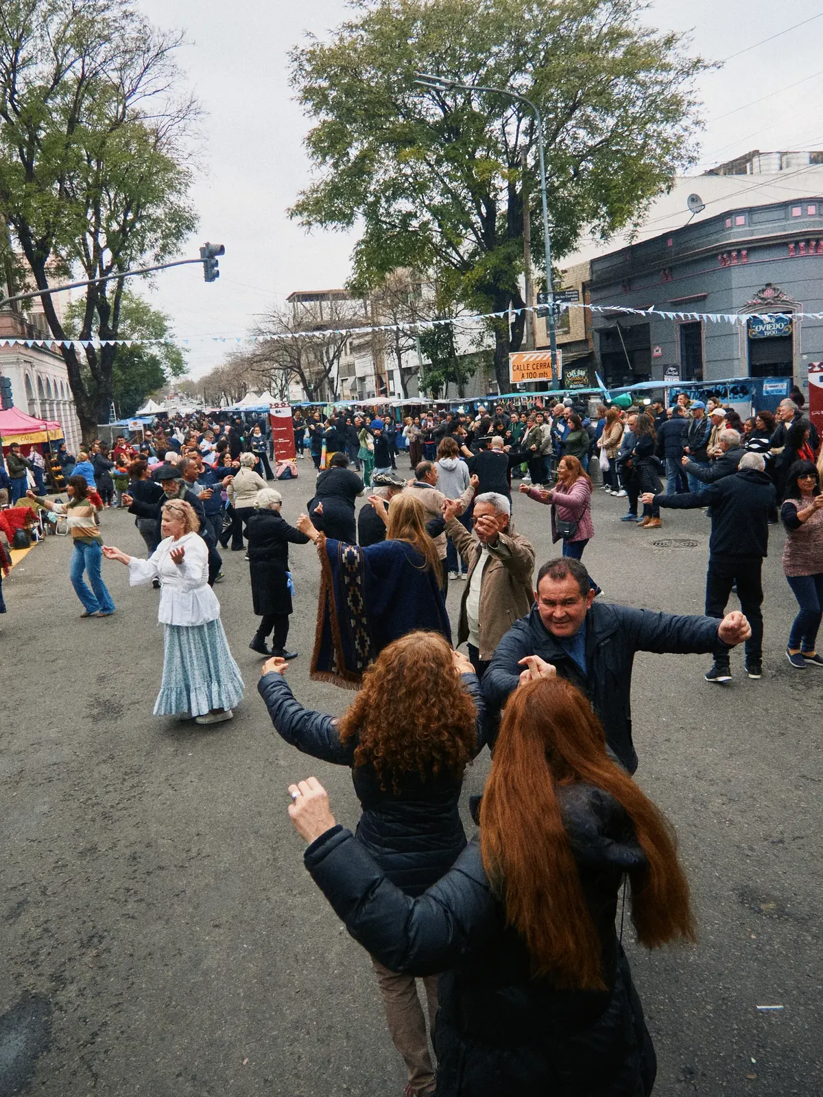 People dancing folk dances in the street at Feria de Mataderos